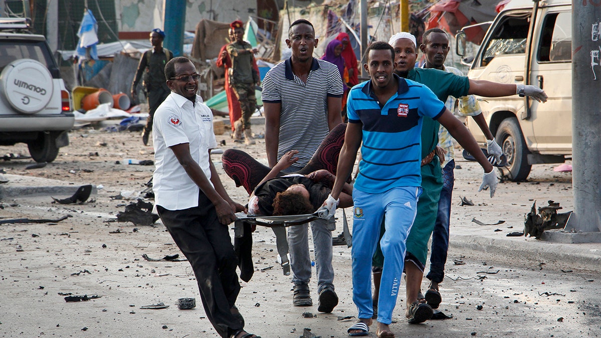 Somalis carry away an injured civilian who was wounded in a bomb blast near the Sahafi hotel in the capital Mogadishu, Somalia.