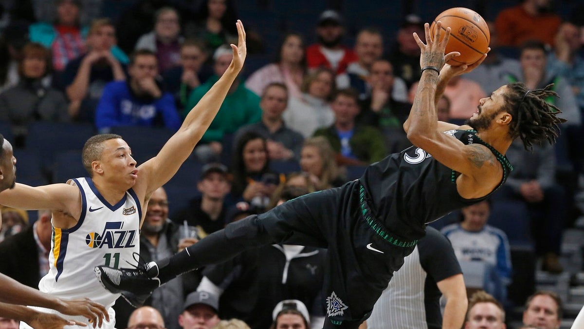 Minnesota Timberwolves' Derrick Rose, right, takes a fall-back shot as Utah Jazz's Dante Exum defends in the first half of an NBA basketball game Wednesday, Oct. 31, 2018, in Minneapolis.