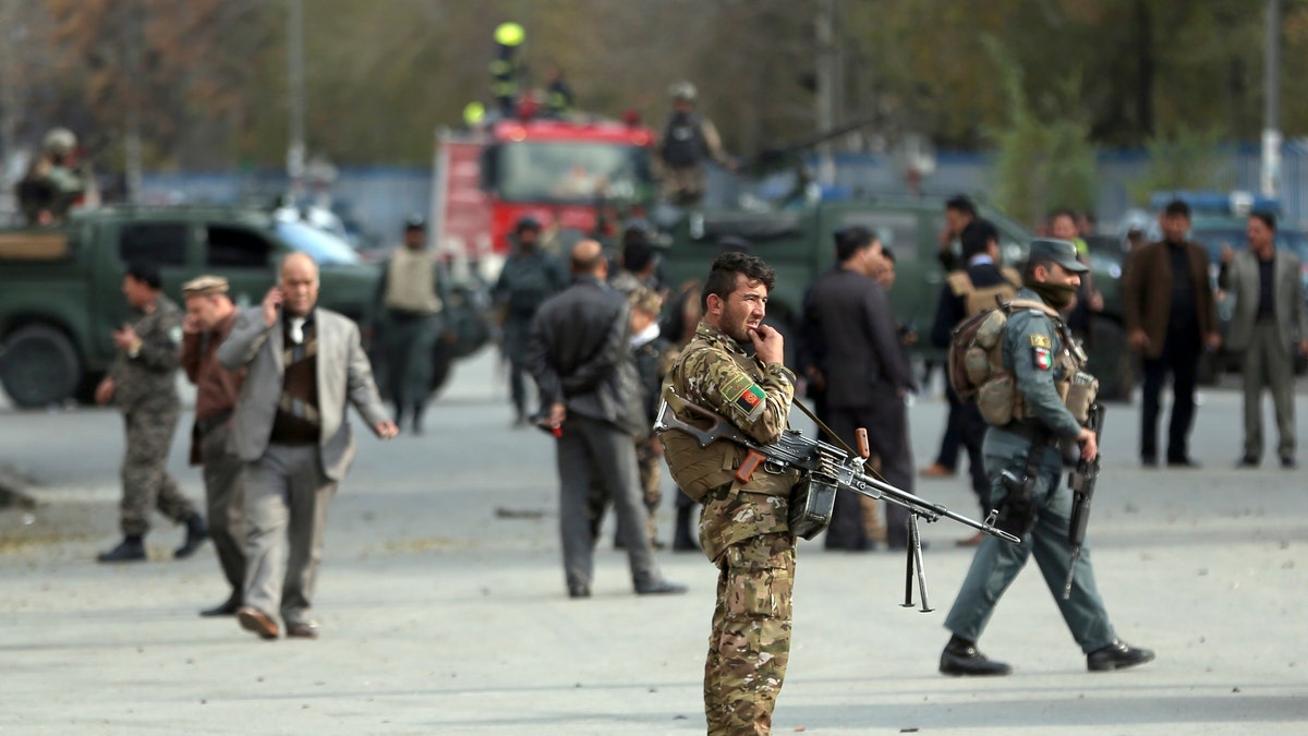 Security forces inspect the site of a deadly blast near a demonstration by hundreds of minority Shiites, in the center of Kabul, Afghanistan, Monday, Nov. 12, 2018. Afghan officials confirmed several people were killed in the explosion near a high school and about 500 meters (yards) from where people gathered to denounce Taliban attacks in Jaghuri and Malistan districts of eastern Ghazni province.
