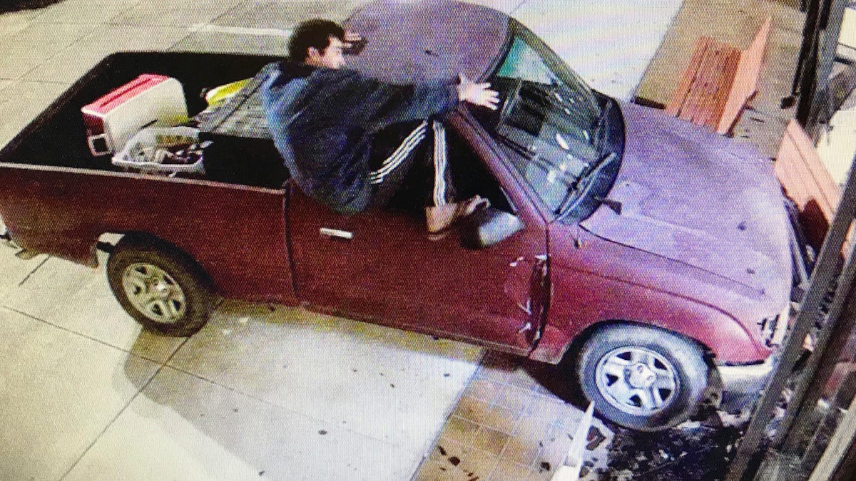 Keith Cavalier is seen climbing out of a Toyota Tacoma truck after it hit the east side of the courthouse in Gulfport, Miss., Saturday morning, Nov. 10, 2018. (Harrison County Board of Supervisors via the AP)