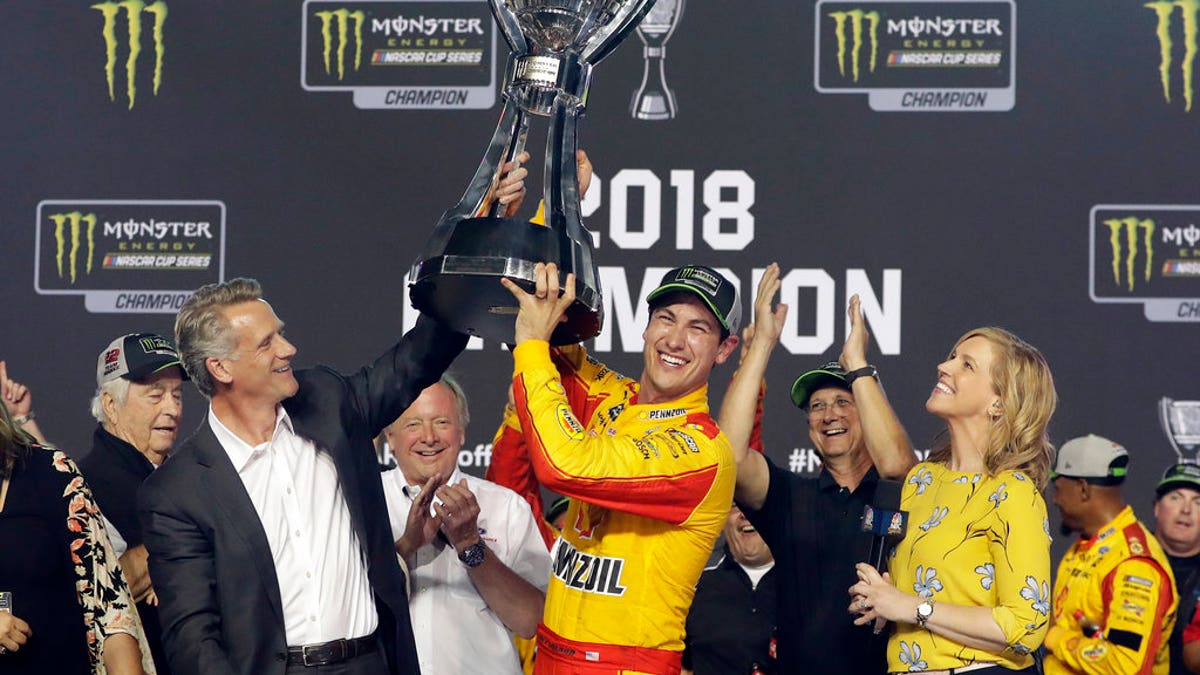 Joey Logano holds the trophy after winning the NASCAR Cup Series Championship auto race at the Homestead-Miami Speedway, Sunday, Nov. 18, 2018, in Homestead, Florida.