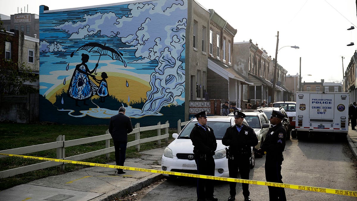 Police gather at the scene of a fatal shooting in the center row home in Philadelphia. (AP)
