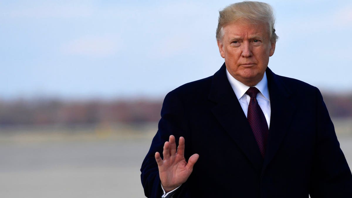 Trump waves to press