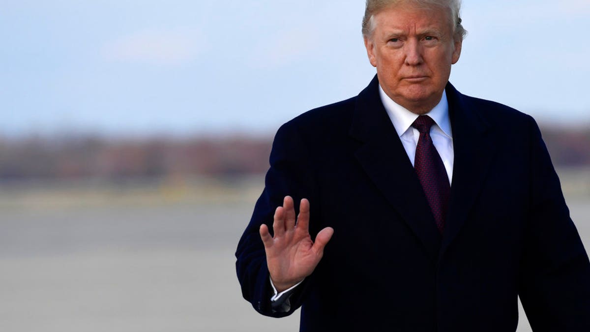 Trump waves to press