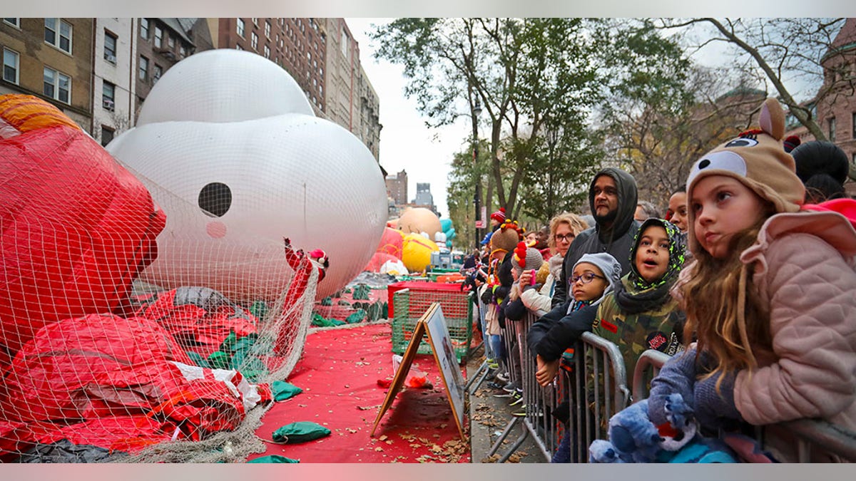 Crowds gather to see giant character balloons being inflated the night before their appearance in the 92nd Macy's Thanksgiving Day parade, Wednesday Nov. 21, 2018, in New York.