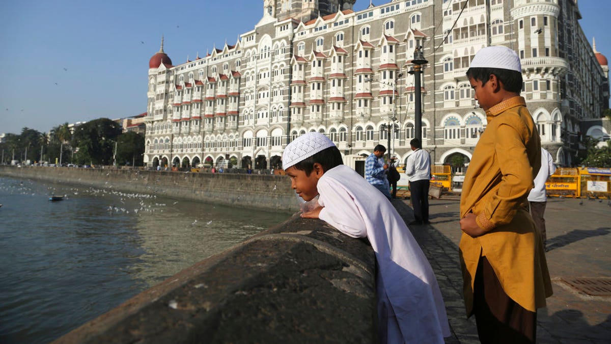 In this Nov 17, 2018, photo, two Muslim boys stand outside the iconic Taj Mahal Palace hotel, the epicenter of the 2008 terror attacks that killed 166 people in Mumbai, India.