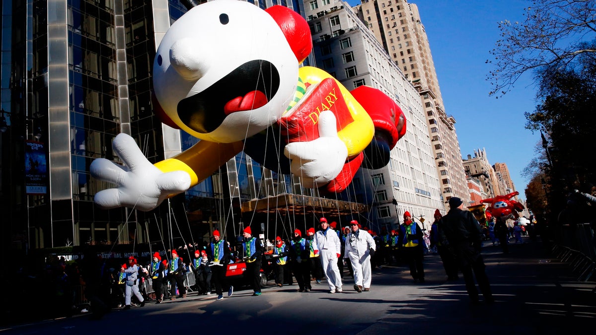 Greg Heffley from the "Diary of a Wimpy Kid" series balloon passes by windows of a building on Central Park West during the 92nd annual Macy's Thanksgiving Day Parade in New York, Thursday, Nov. 22, 2018. (AP Photo/Eduardo Munoz Alvarez)