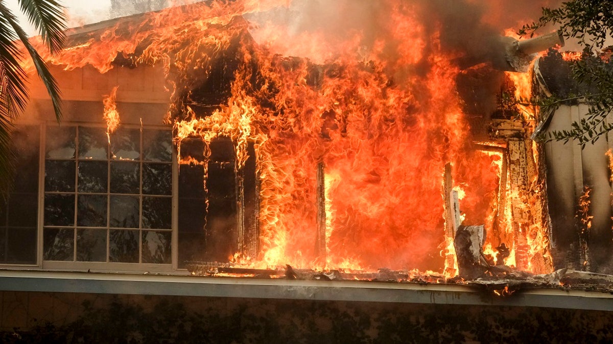 The Woolsey Fire burns a home near Malibu Lake in Malibu, Calif., Friday, Nov. 9, 2018.