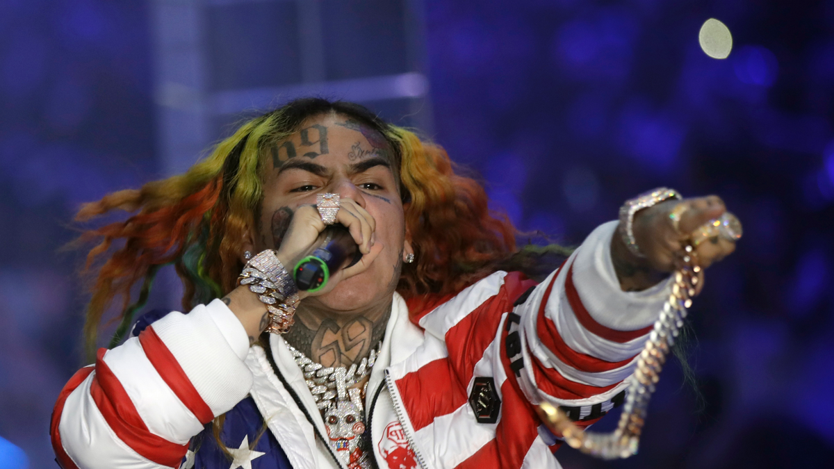 Rapper Tekashi 6ix9ine wearing an American flag jacket at a performance in Italy