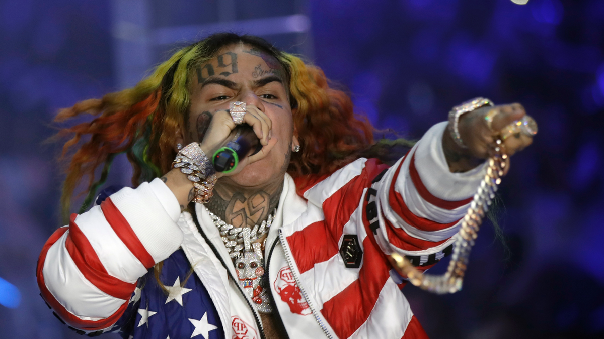 Rapper Tekashi 6ix9ine wearing an American flag jacket at a performance in Italy