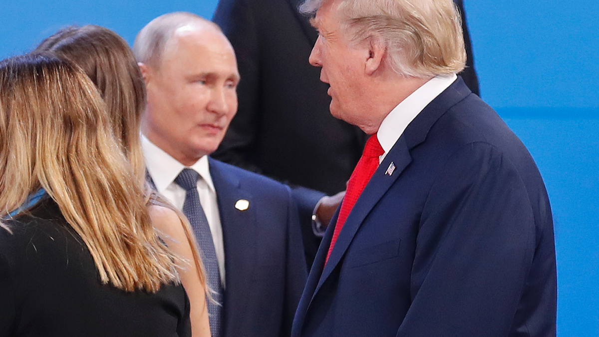 Russia's President Vladimir Putin, left, watches President Donald Trump, right, walk past him as they gather for the group photo at the start of the G20 summit in Buenos Aires, Argentina, Friday, Nov. 30, 2018. Leaders from the Group of 20 industrialized nations are meeting in Buenos Aires for two days starting today.(AP Photo/Pablo Martinez Monsivais)