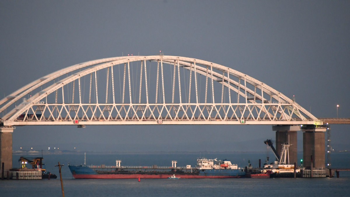 A ship under the the Kerch bridge blocks the passage to the Kerch Strait near Kerch, Crimea, Sunday, Nov. 25, 2018. Ukraine claims it siezed the Russian tanker Wednesday in a move that could put a potential prisoner swap in jeopardy. (AP Photo)