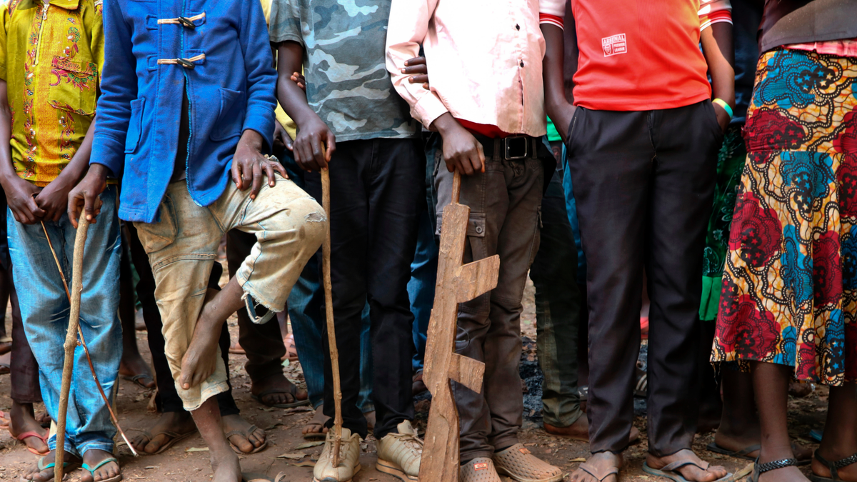 FILE - In this Wednesday, Feb. 7, 2018 file photo, former child soldiers stand in line waiting to be registered with UNICEF to receive a release package, in Yambio, South Sudan. In an interview with The Associated Press in civil war-torn South Sudan, Romeo Dallaire, the former commander of the failed U.N. peacekeeping mission during the Rwandan genocide, says the current approach to combatting child soldier recruitment is not "sufficient". (AP Photo/Sam Mednick, File)