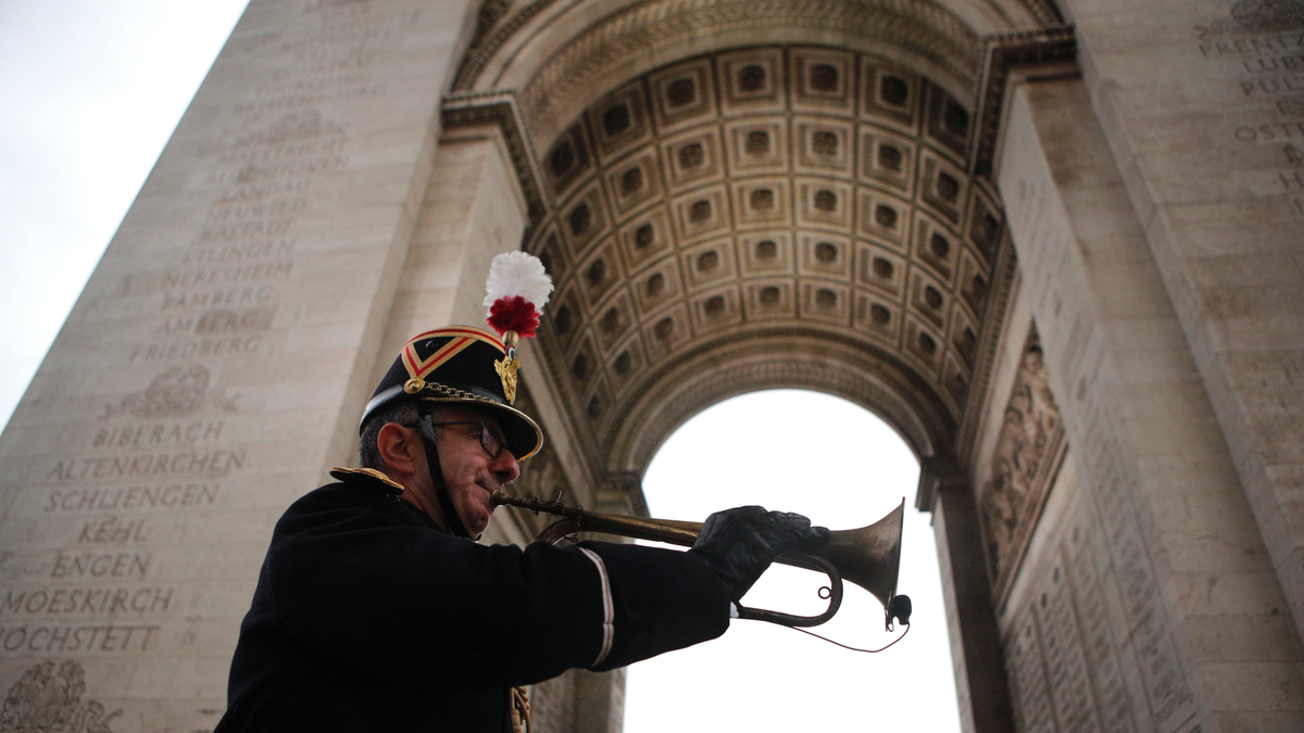 Military officer Garcia plays the original Armistice bugle from 1918 under the Arc de Triomphe Sunday, Nov. 11, 2018 in Paris. More than 60 heads of state and government are in France for the Armistice ceremonies at the Tomb of the Unknown Soldier in Paris on the 11th hour of the 11th day of the 11th month, exactly a century after the armistice. (AP Photo/Francois Mori, Pool)