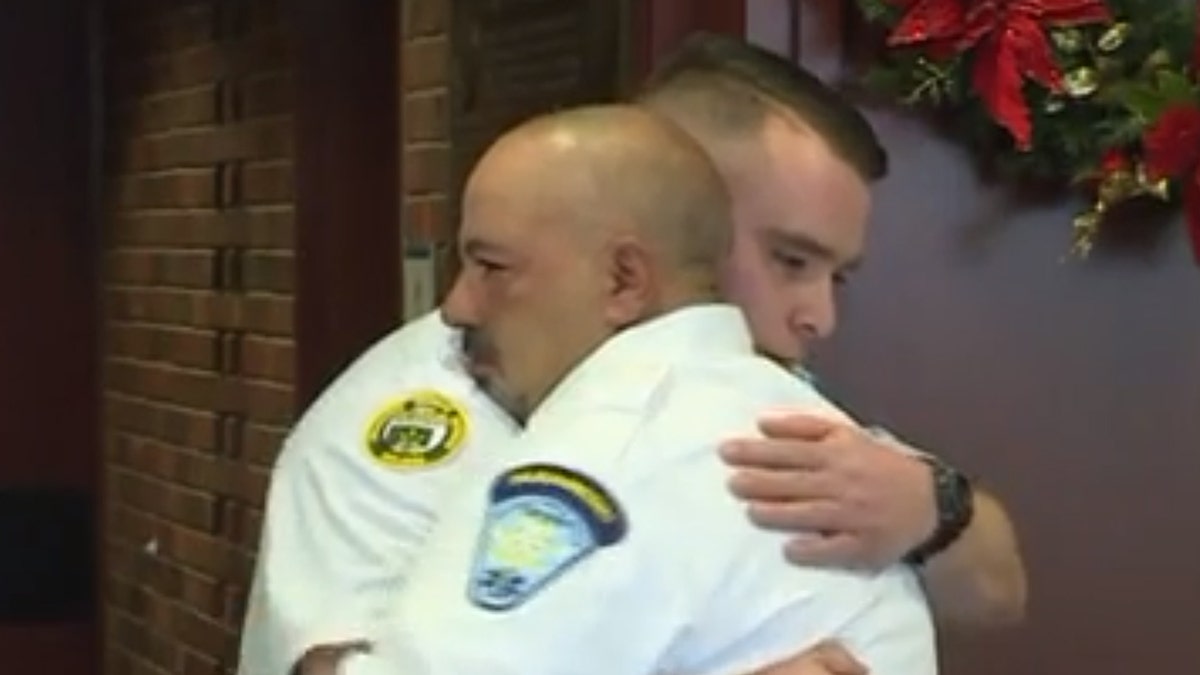EMT partners Chris Cabral and Ray Berwick embrace at a ceremony celebrating Berwick's actions that helped save Cabral following his stroke.