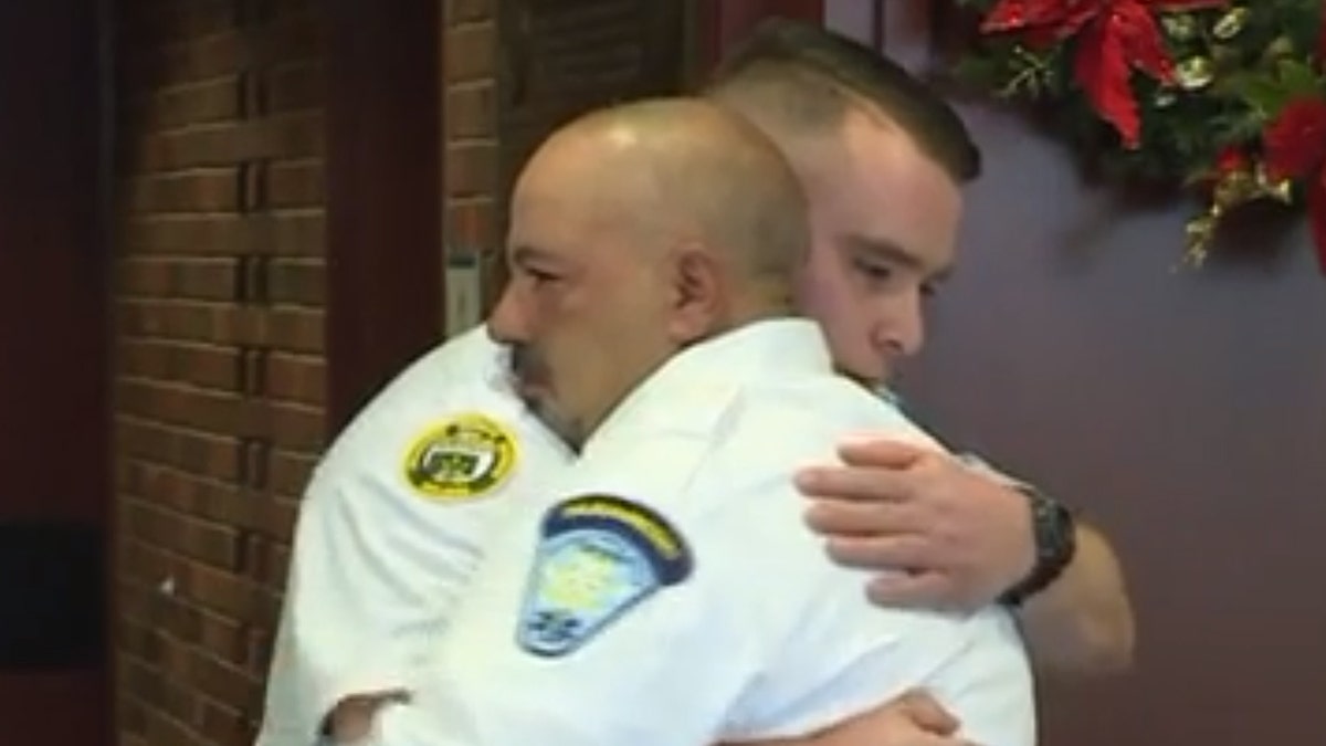 EMT partners Chris Cabral and Ray Berwick embrace at a ceremony celebrating Berwick's actions that helped save Cabral following his stroke.