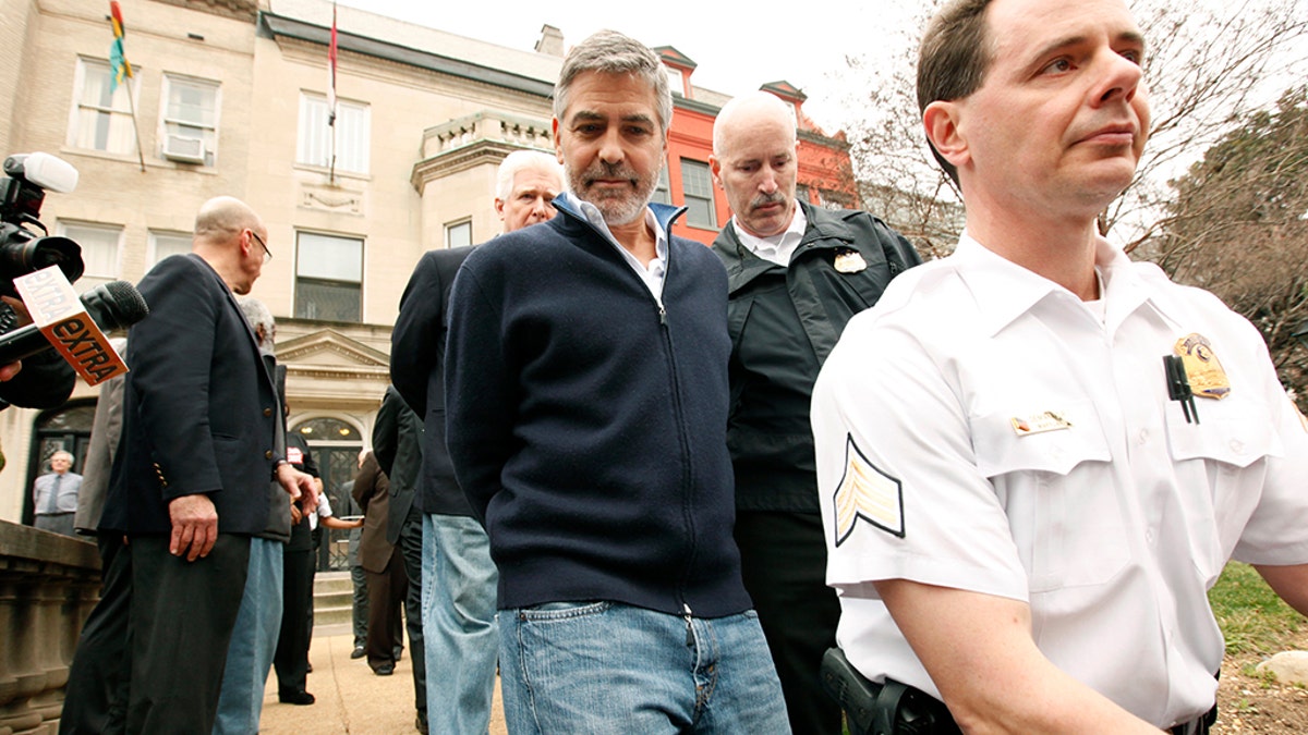 Actor George Clooney is arrested for civil disobedience after protesting at the Sudan Embassy in Washington on March 16, 2012. Clooney was protesting the escalating humanitarian crisis in Sudan. REUTERS/Kevin Lamarque (