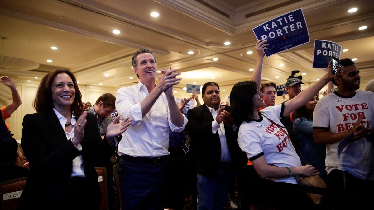 Sen. Kamala Harris, D-Calif., left, and California gubernatorial Democratic candidate Gavin Newsom applaud as they listen to Katie Porter, a congressional candidate for California's 45th District, during a campaign rally Saturday, Nov. 3, 2018, in Irvine, Calif. The fight for control of the U.S. House is attracting big names to historically Republican Orange County, California. The candidates for governor, Democrat Gavin Newsom and Republican John Cox, are each scheduled to campaign with House candidates Saturday in the run-up to Tuesday's election. (AP Photo/Jae C. Hong)
