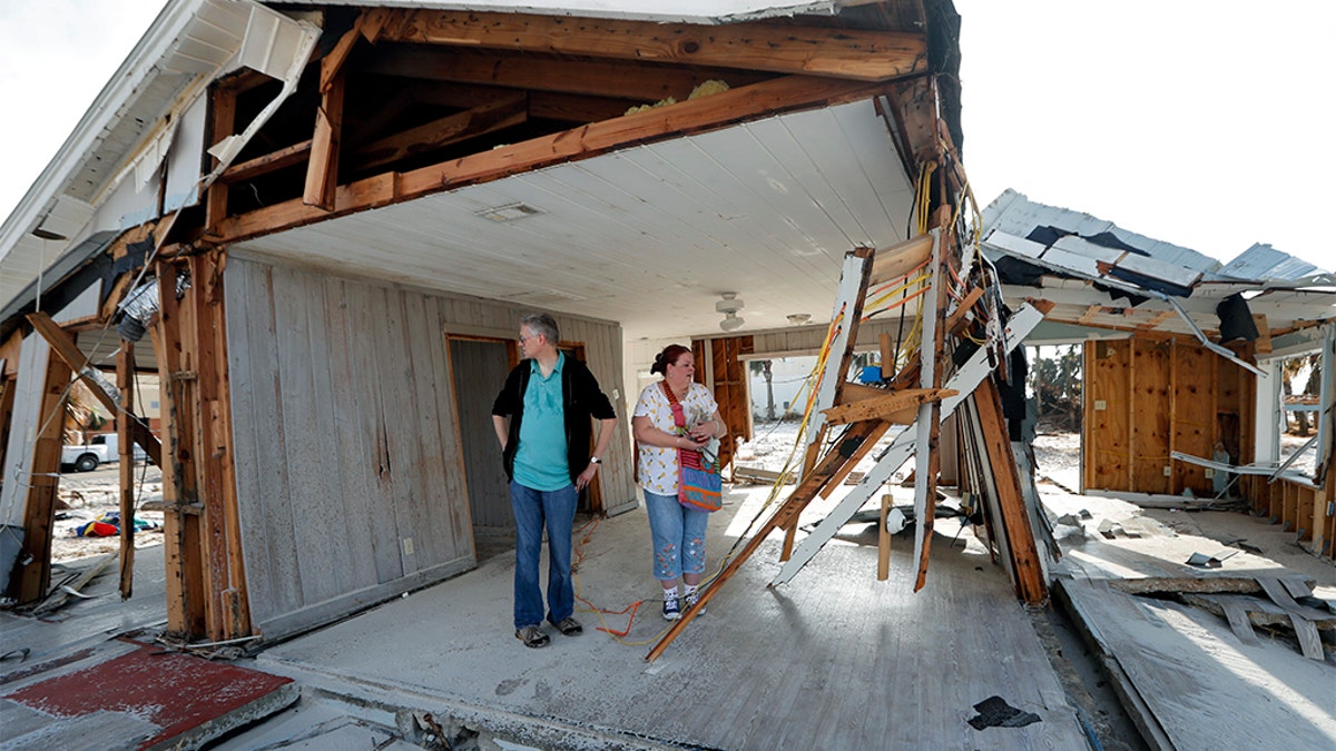 Lanie Eden and her husband Ron stand in the destroyed vacation home they rented every year as they look for their possessions in the aftermath of Hurricane Michael in Mexico Beach, Fla. The region in the battleground state is still trying to recover from Michael, which pummeled several counties in the Florida Panhandle and was responsible for dozens of deaths, and among the ruins are polling stations in a GOP mainstay. (AP Photo/Gerald Herbert, File)