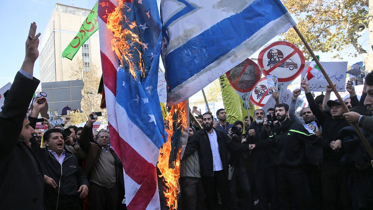 Iranian demonstrators burn representations of the U.S. and Israeli flags during a rally in front of the former U.S. Embassy in Tehran, Iran, on Sunday, Nov. 4, 2018.