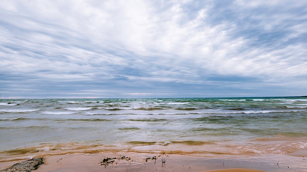 A man died and a woman remains missing Monday after they encountered hazardous conditions while swimming in Lake Michigan, officials said.
