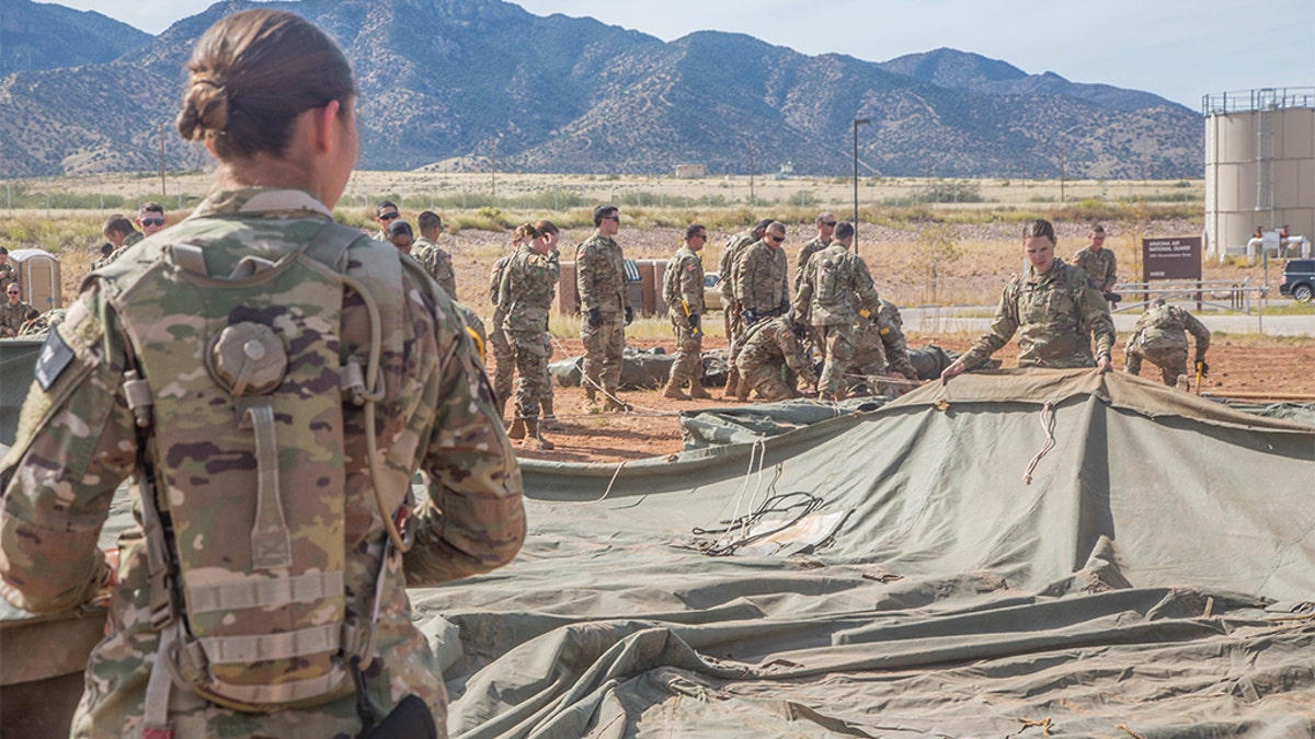 U.S. Army soldiers, assigned to 309th Military Intelligence Battalion and 305th Military Intelligence Battalion, positioning a tent on Fort Huachuca, Arizona.
