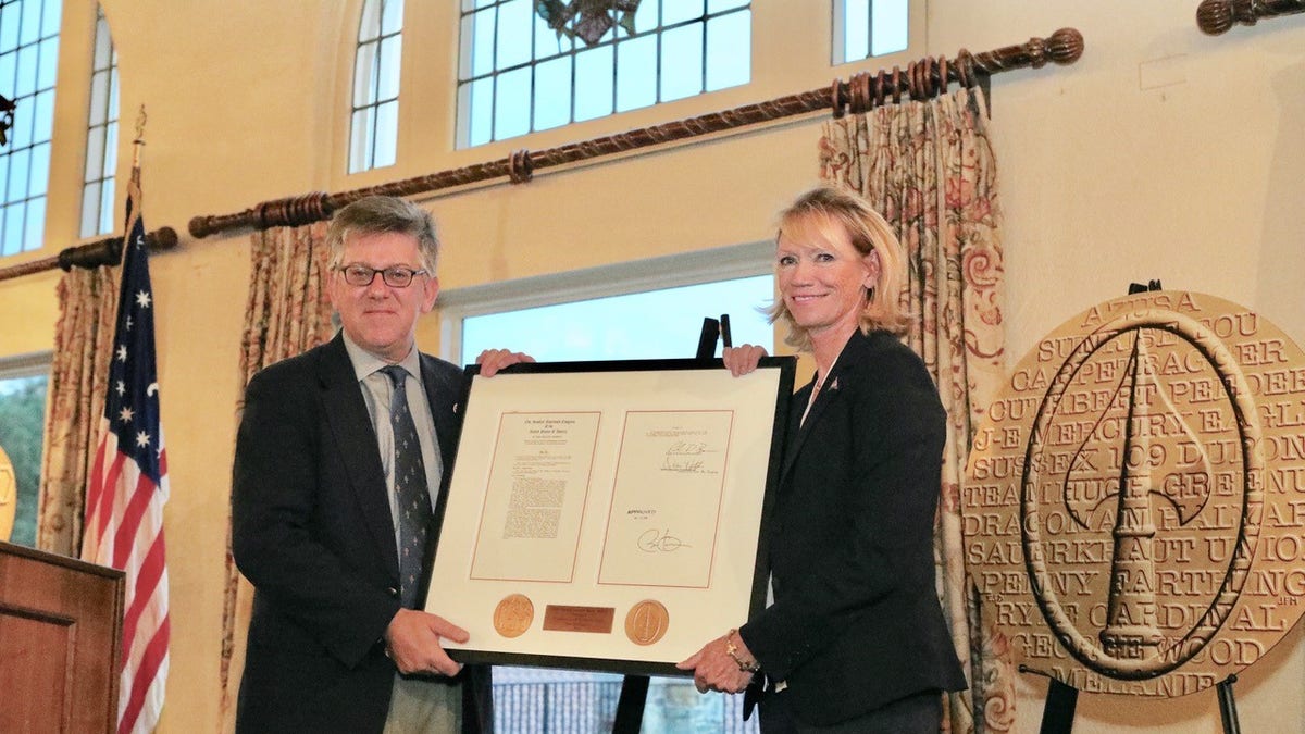 Charles Pinck presented a replica of the O.S.S. Congressional Gold Medal that the society received earlier this year to Congressional Country Club president, Bev Lane, in a recent ceremony, which also honored the veterans taking part in the PGA Hope program. (Courtesy of Dr. Ed Gwozdz)