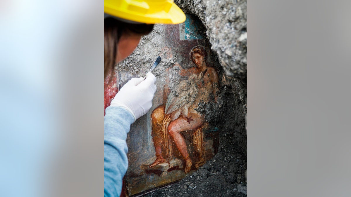 An archeologist cleans up the fresco ''Leda e il cigno'' (Leda and the swan). (Cesare Abbate/ANSA via AP) 
