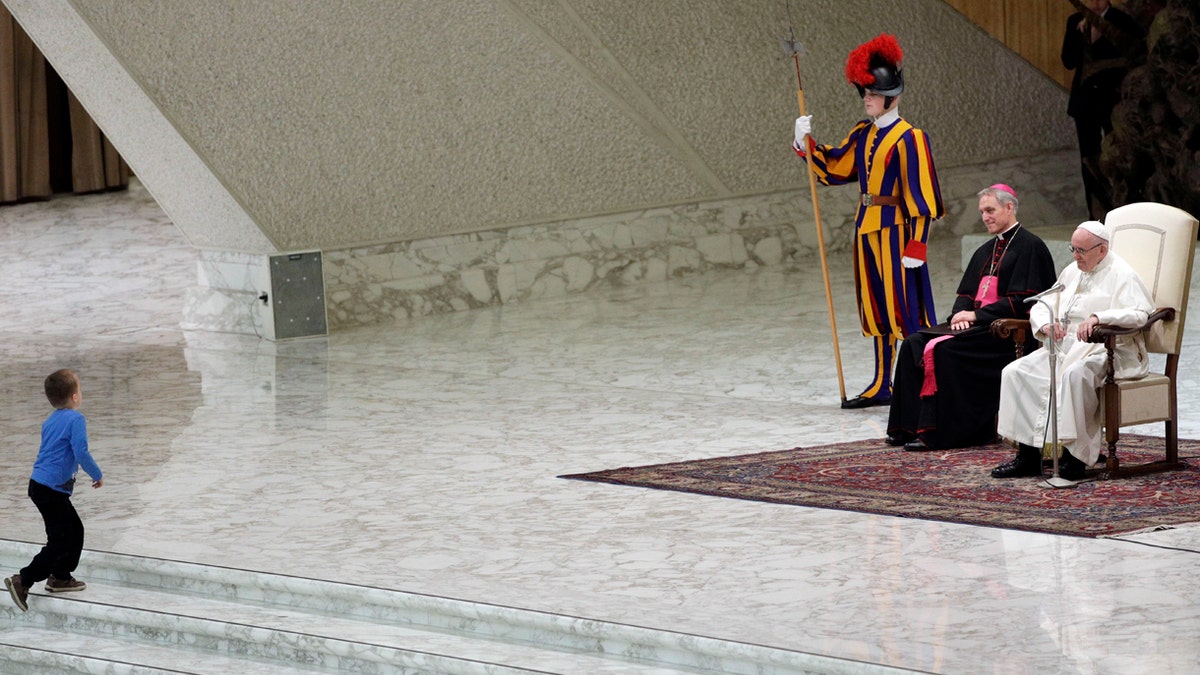 A child makes his way to the stage during Pope Francis weekly general audience, in the Paul VI Hall at the Vatican, Wednesday, Nov. 28, 2018.