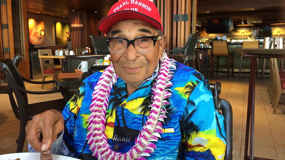 In this Monday, Dec. 5, 2016 photo, Ray Chavez, a Pearl Harbor survivor from Poway, Calif., pauses while eating breakfast in Honolulu. (AP Photo/Audrey McAvoy)