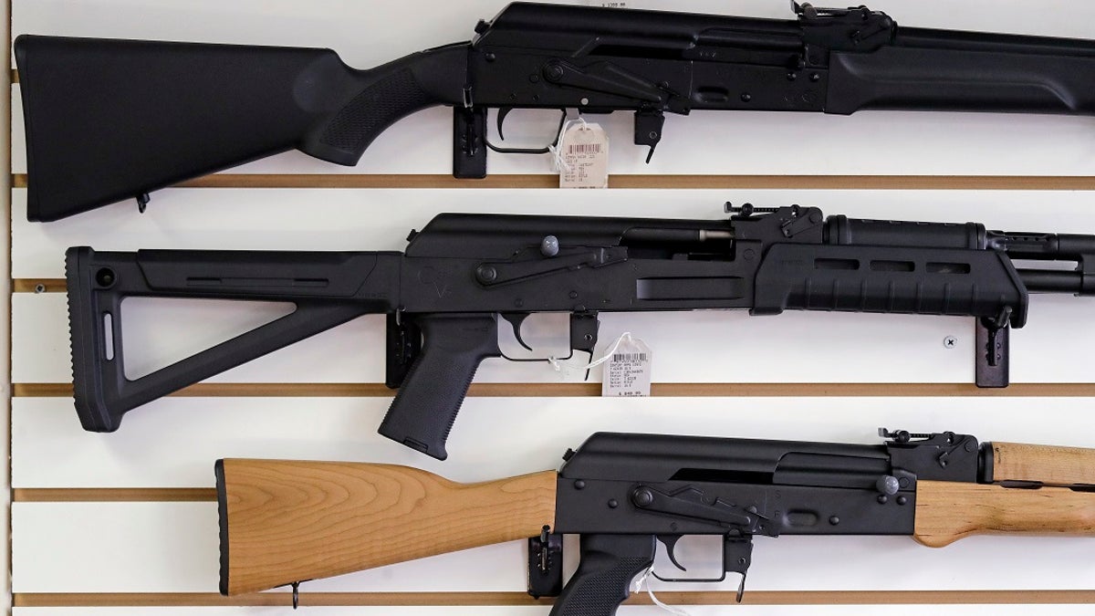 FILE - Semi-automatic rifles are displayed on a wall at a gun shop.