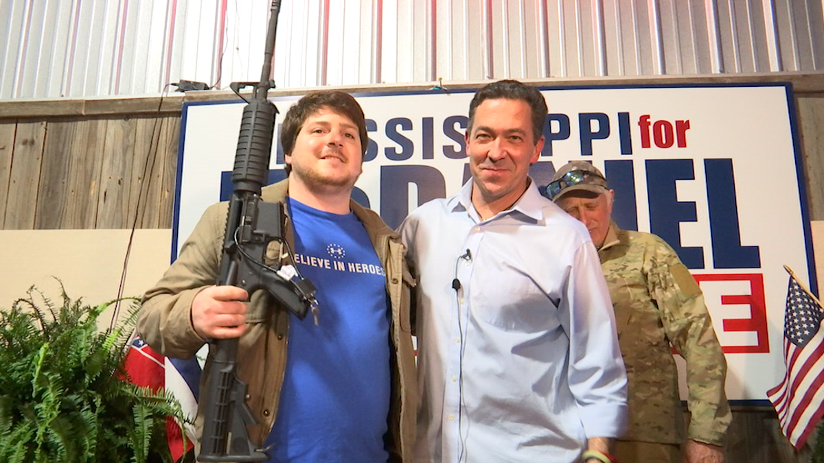 McDaniel poses with a supporter, who won the raffle for an AR-15 rifle ahead of Mississippi's special election.