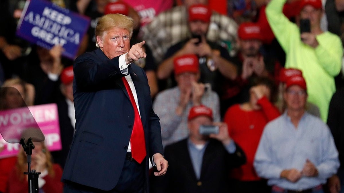 President Donald Trump points to the crowd as he leaves the stage at the end of a campaign rally Monday.