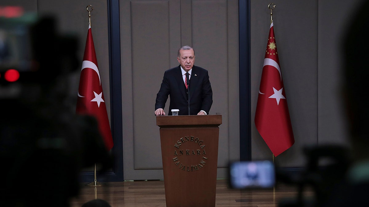 Turkey's President Recep Tayyip Erdogan talks to members of the media at the airport in Ankara, Turkey, Saturday. (Presidential Press Service via AP)