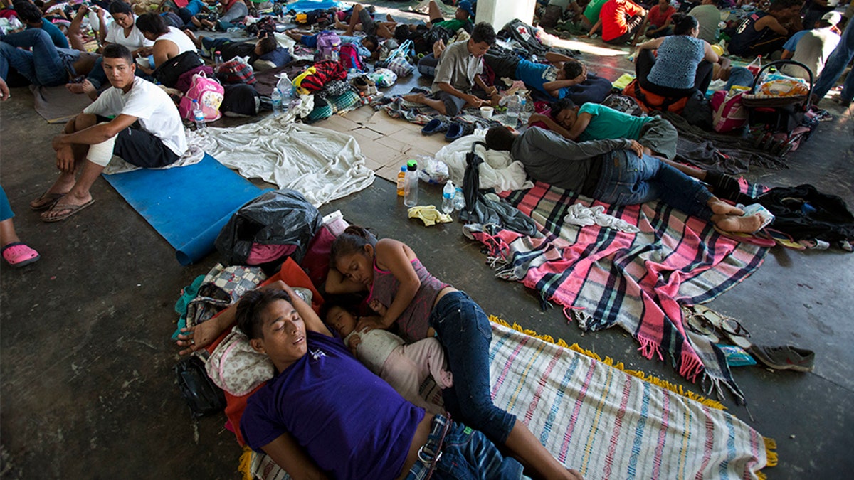 People rest on the ground in a municipal lot serving as a makeshift campground, as a caravan of Central Americans hoping to reach the U.S. border takes a rest day in Juchitan, Mexico, on Wednesday.