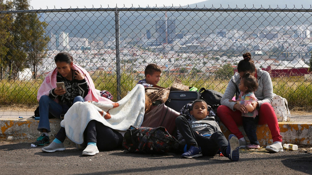 Central American migrants rest outside a soccer stadium after arriving in Queretaro, Mexico, as they resume their journey north.