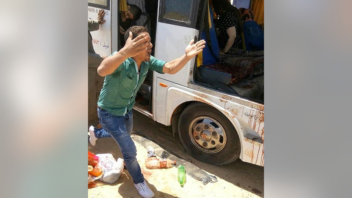 A man screams beside a bus carrying Coptic Christians which came under attack outside Cairo, Friday, Nov. 2, 2018.