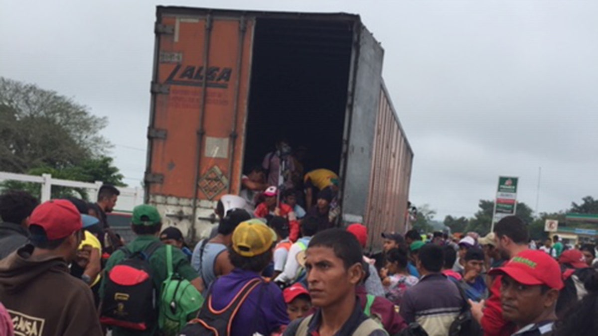 Migrants rush to get into truck as they continue trek to U.S. border on Sunday, November 4, 2018.