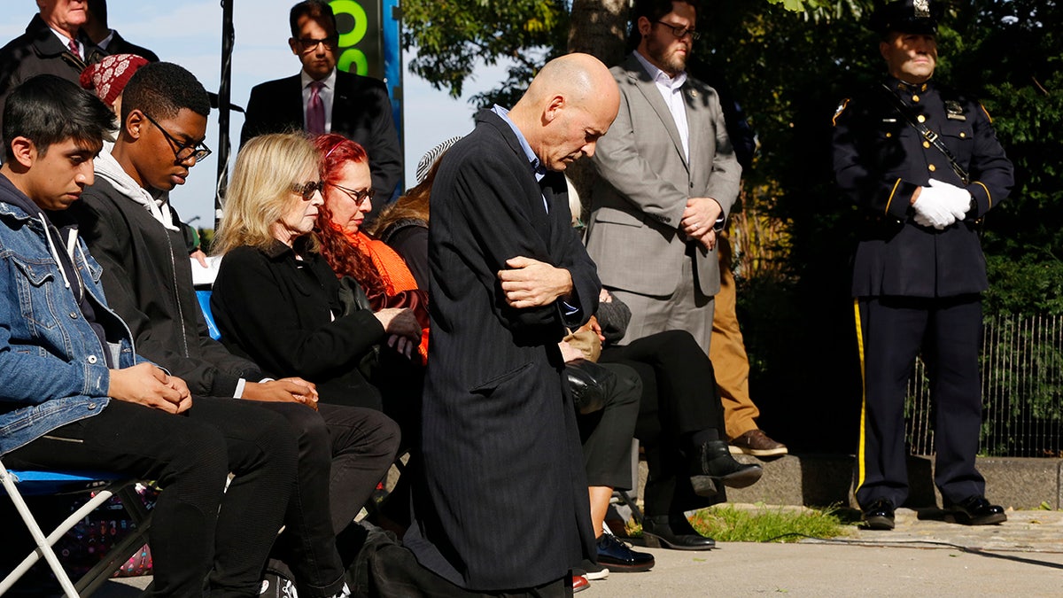 Hugh Hales-Tooke, a friend of victim Nicholas Cleves, kneels during a moment of silence during a ceremony marking the anniversary of the Hudson River Park bike path attack.