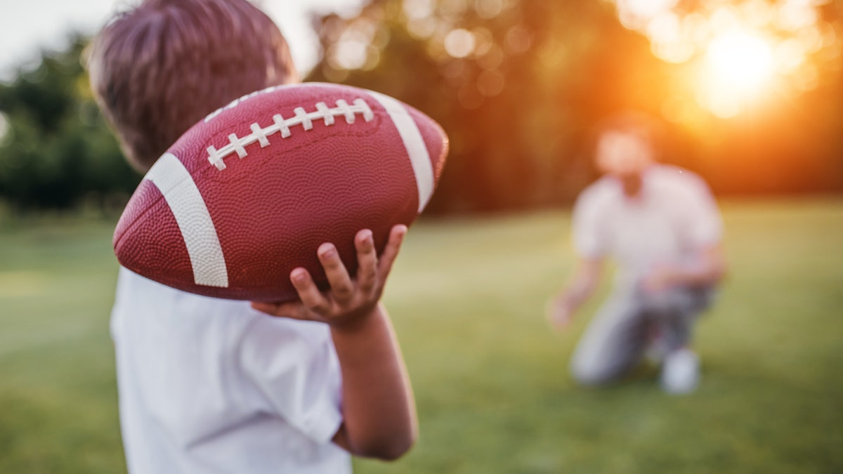 dad ad boy throwing football