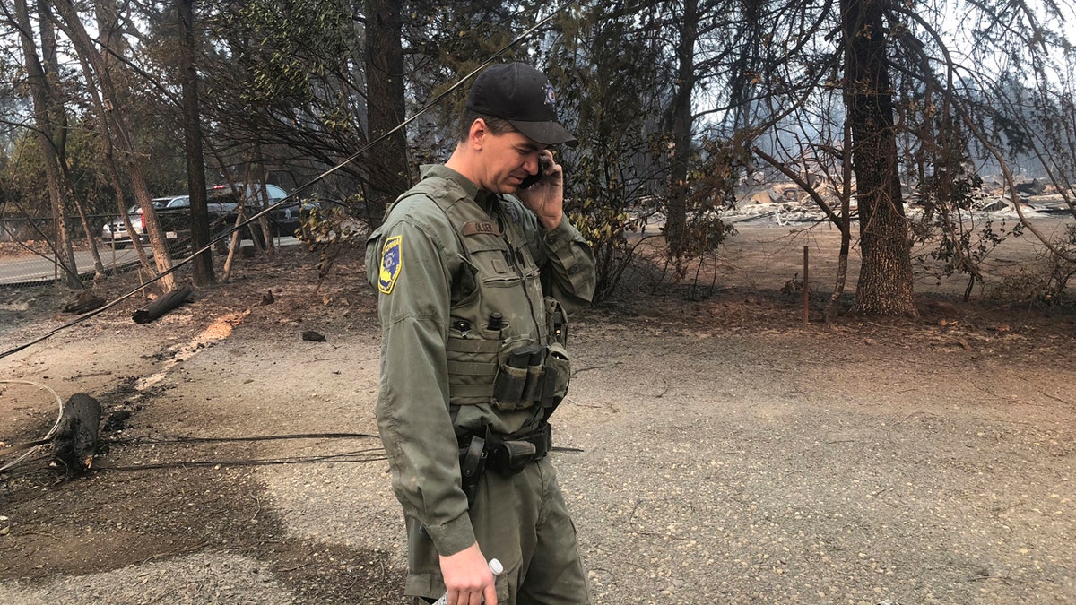 California Department of Fish and Wildlife warden Jake Olsen tells his wife her wedding ring was found in the ashes of their home they share with their four children in Paradise, Calif.