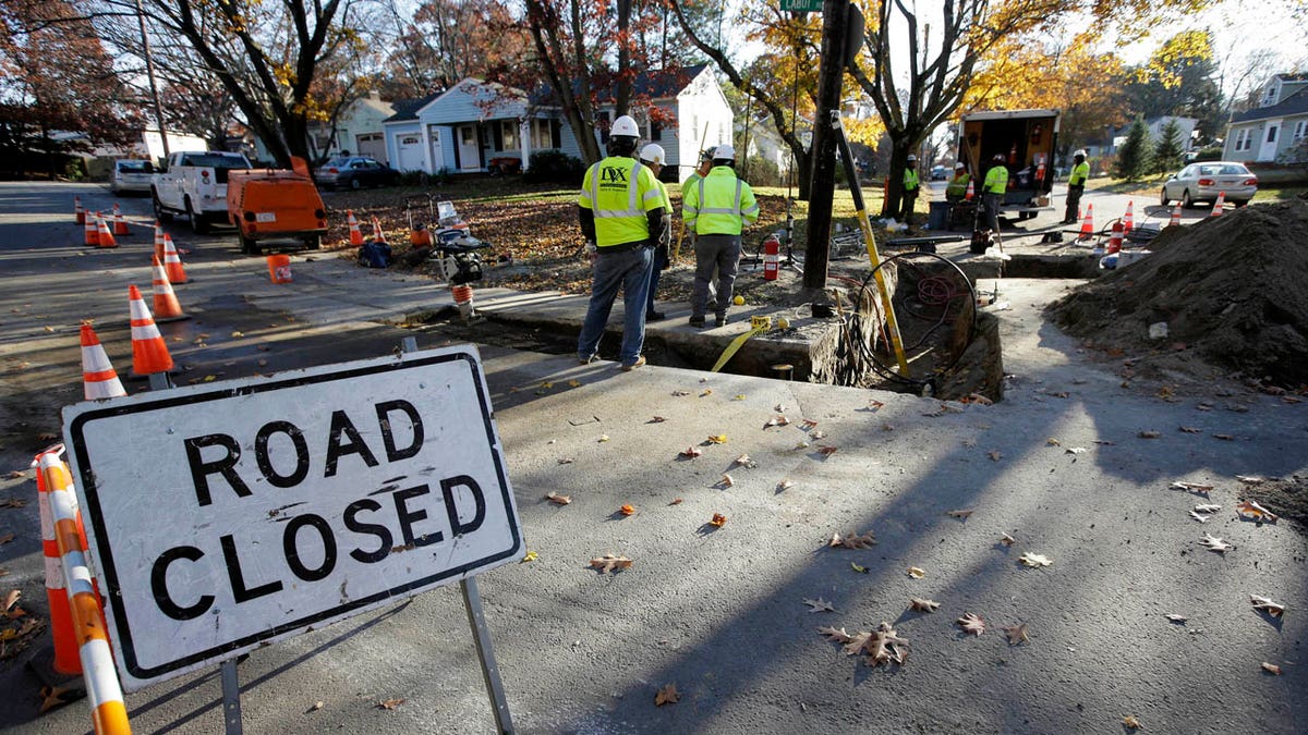 In this Thursday, Nov. 8, 2018 photo, natural gas contract workers repair underground gas lines in Lawrence, Mass.