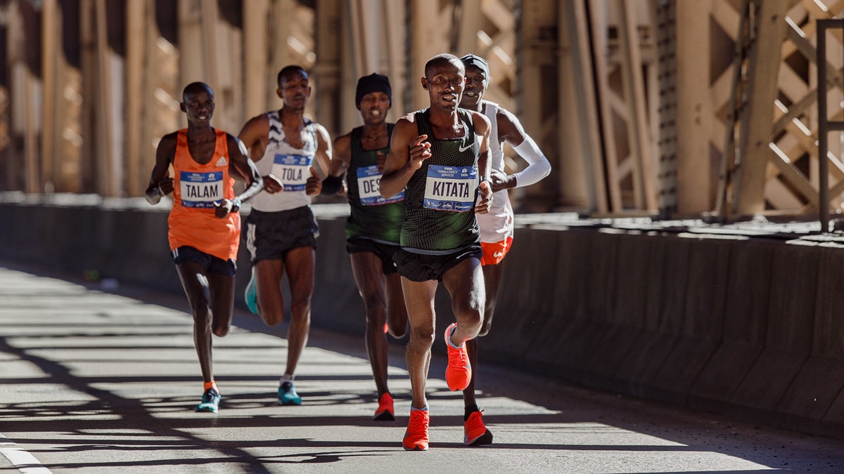 Tola Shura Kitata, of Ethiopia, front, runs with the men's pack as they cross the Queensboro bridge during the New York City Marathon in New York, Sunday, Nov. 4, 2018.