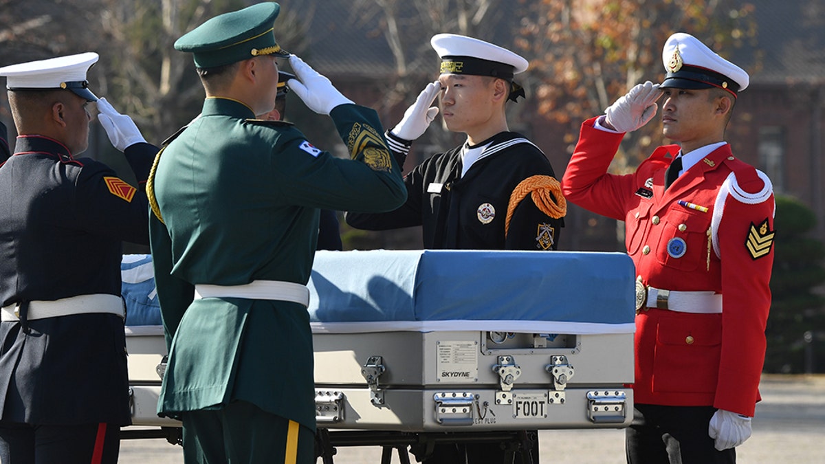 United Nations Command honor guards salute a casket containing the remains of an unidentified Korean War UN forces soldier during a repatriation ceremony at a US Army base in Seoul on November 20, 2018.