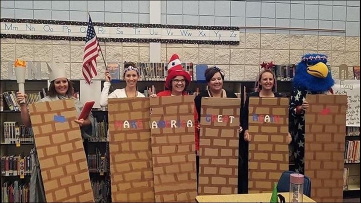 A school district is investigating after photos showed school employees dressed as a border wall.