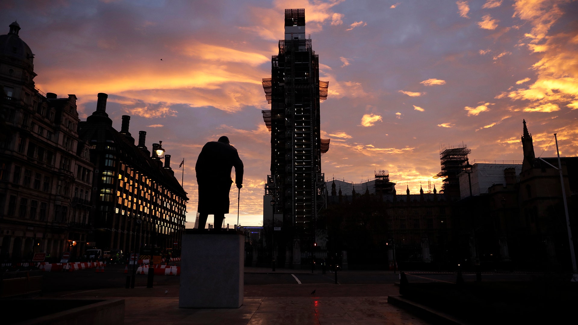 The sun rises as seen in Parliament Square with the statue of former Prime Minister Winston Churchill in the foreground in London, November 14, 2018.  