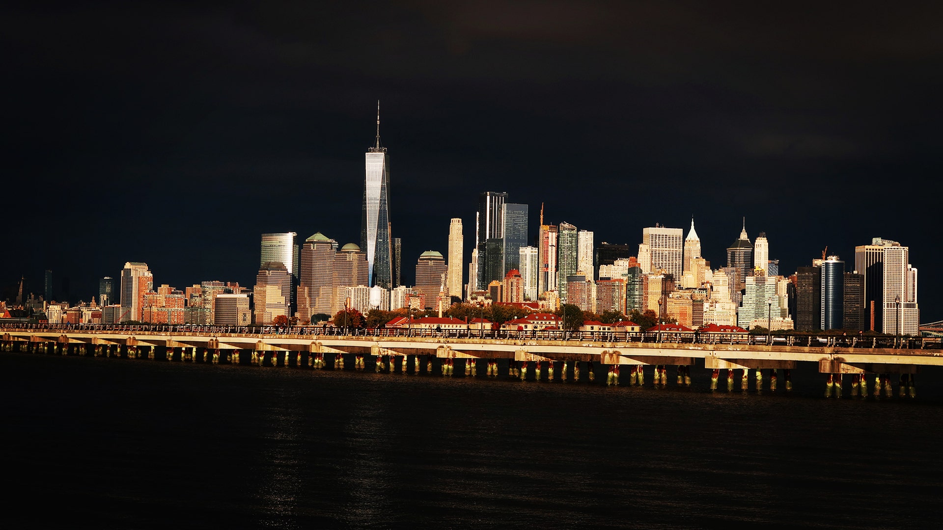 The sun sets on the skyline of lower Manhattan on a cloudy day in New York City, Oct. 28, 2018.