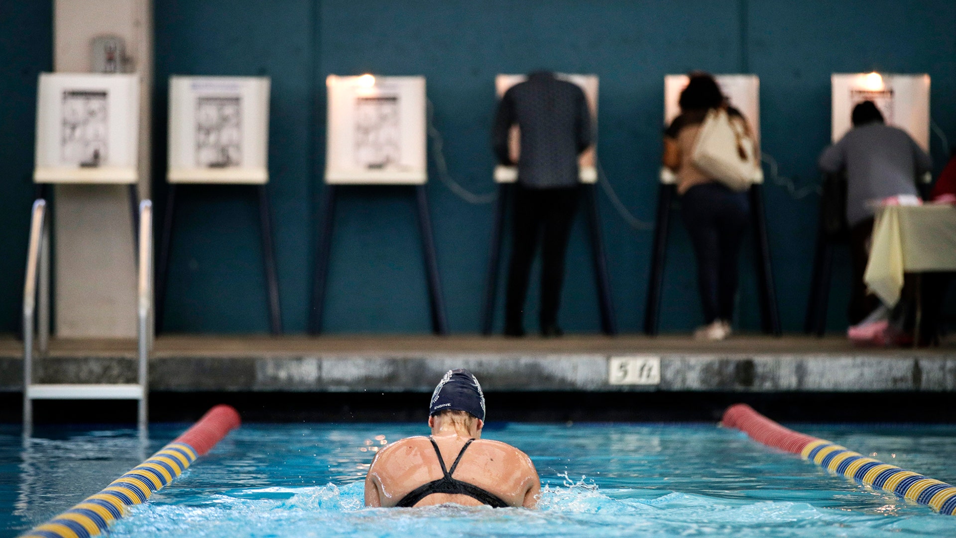 Sarah Salem swims as voters cast their ballots at Echo Deep Pool in Los Angeles, November 6, 2018. 