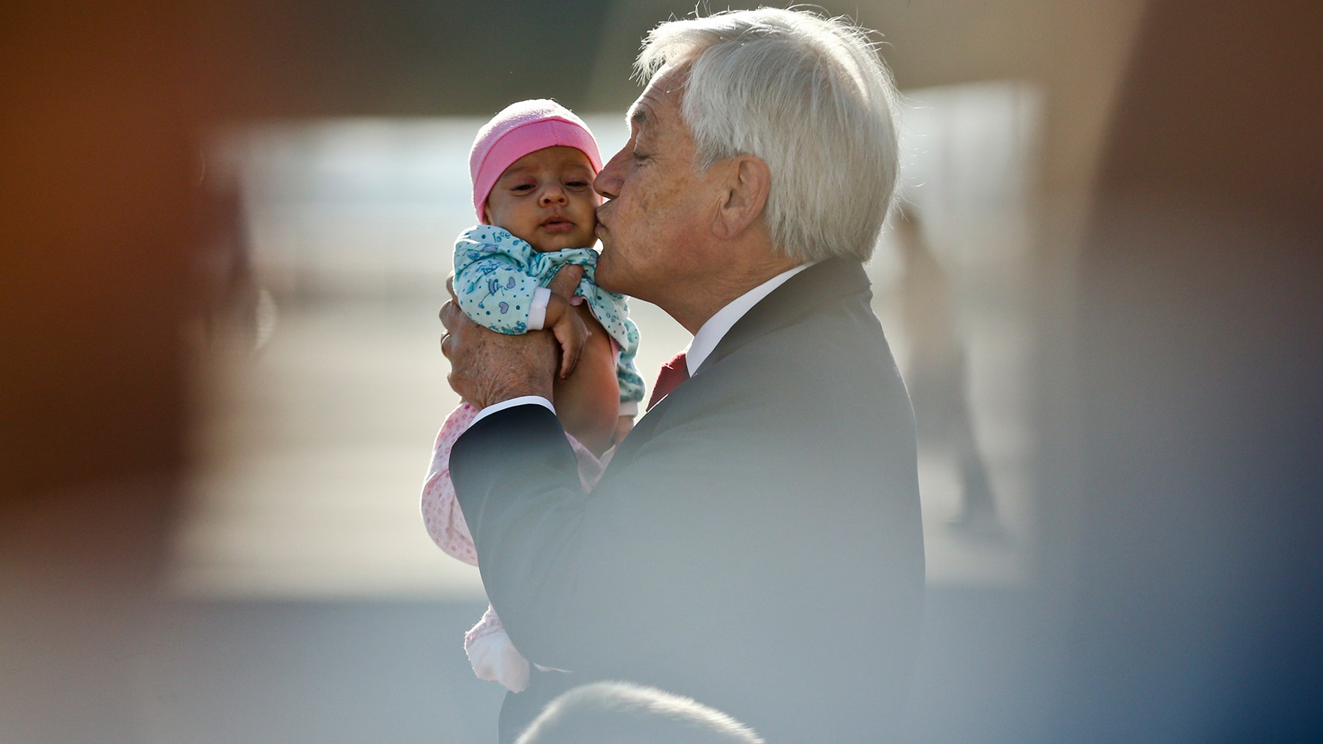 Chile's President Sebastian Pinera kisses a baby as he receives a group of repatriates at the international airport in Santiago, Chile, Nov. 27, 2018. 