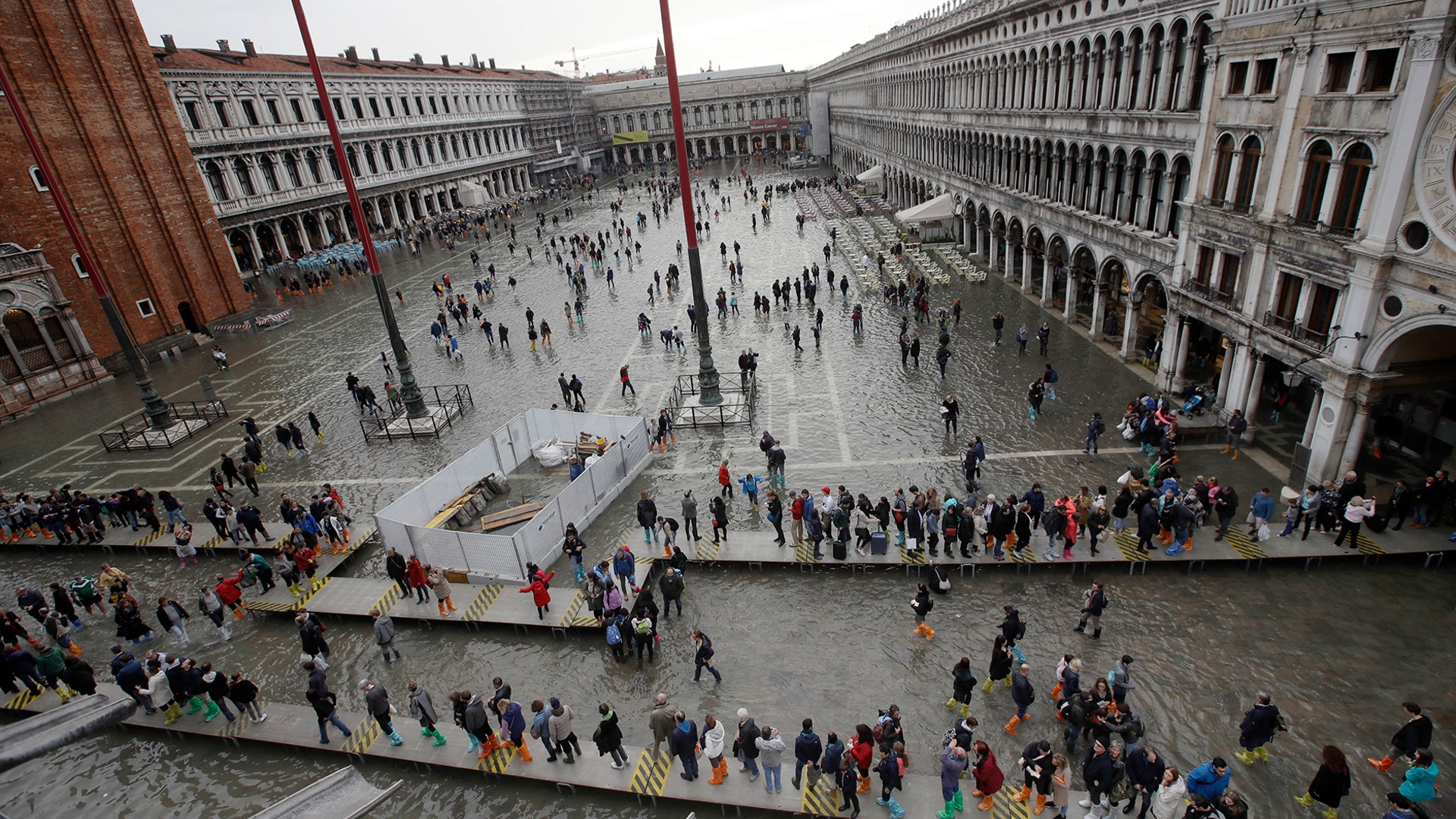 As rainstorms and strong winds batter Italy, tourists cross a flooded St. Mark's Square in Venice, Nov. 1, 2018.